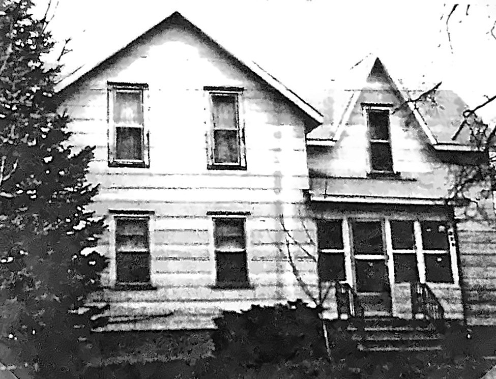 Black and white photograph of the Maynard house: a two-storey white frame house with a gabled porch